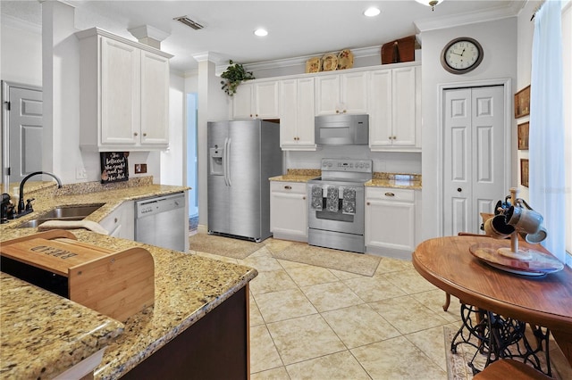 kitchen featuring light stone countertops, ornamental molding, stainless steel appliances, sink, and white cabinets