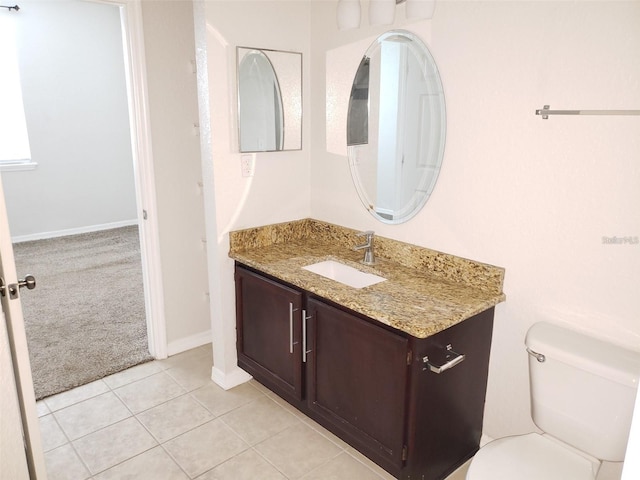 bathroom with tile patterned flooring, baseboards, vanity, and toilet