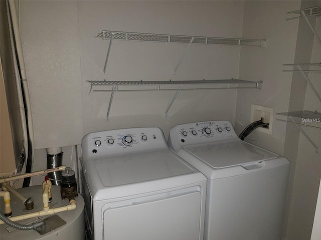 laundry area with water heater, laundry area, and washer and dryer