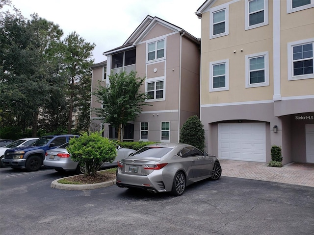 view of building exterior with a garage and decorative driveway