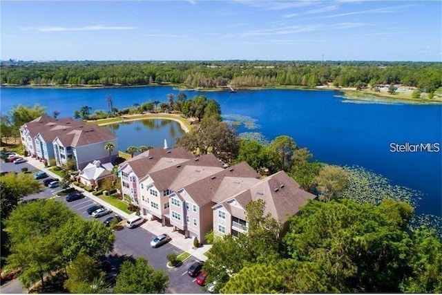 birds eye view of property with a water view and a view of trees