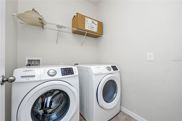 laundry room with washer and dryer and light tile patterned floors