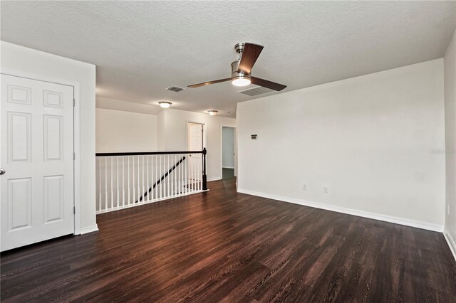 spare room with ceiling fan, dark hardwood / wood-style floors, and a textured ceiling