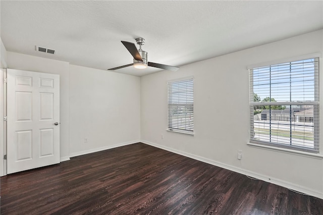 spare room with dark hardwood / wood-style flooring and ceiling fan