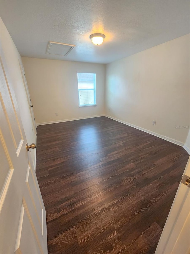 unfurnished room featuring dark hardwood / wood-style floors and a textured ceiling