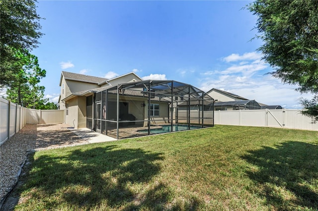 rear view of house featuring a fenced in pool, a patio, a lanai, and a lawn