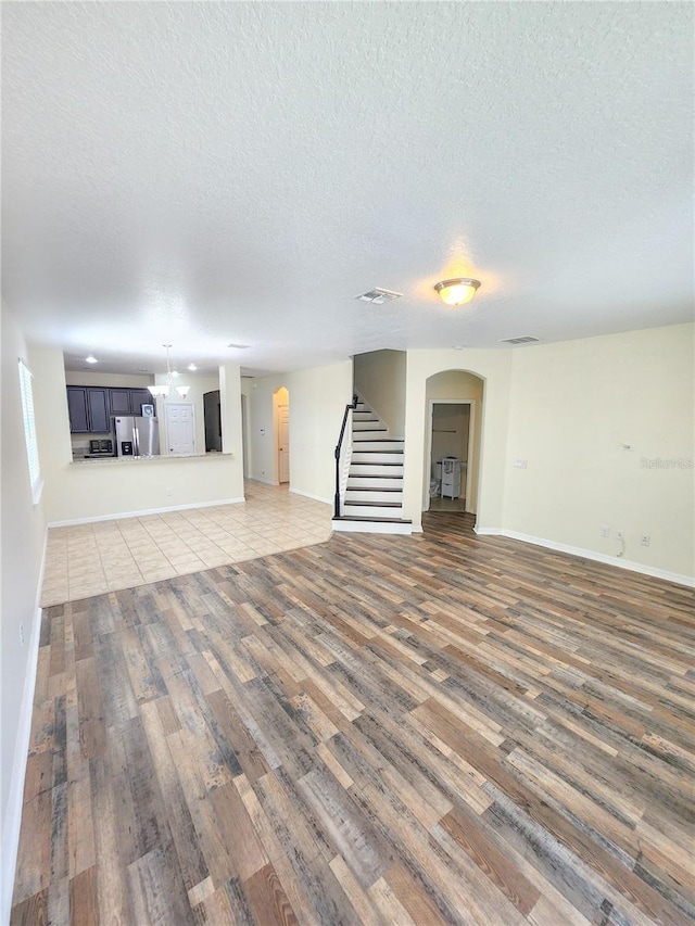 unfurnished living room with a textured ceiling and dark wood-type flooring