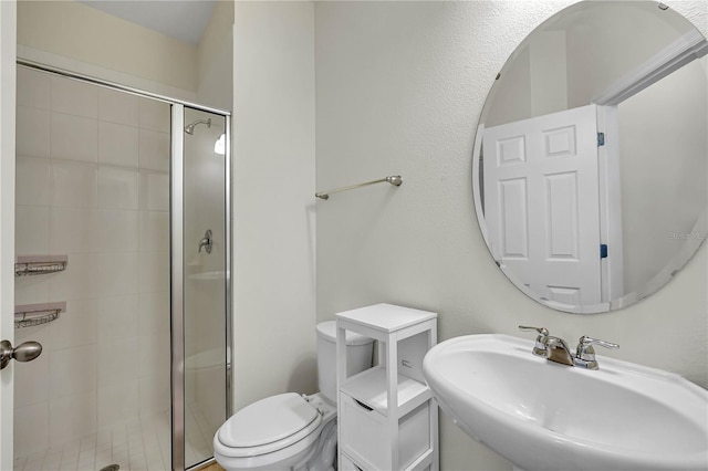 bathroom with sink, an enclosed shower, and toilet