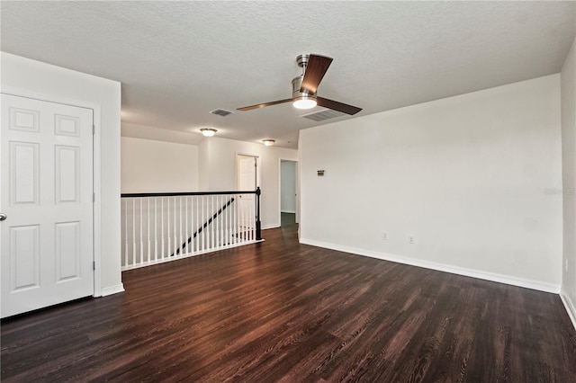 empty room featuring a textured ceiling, ceiling fan, and dark hardwood / wood-style floors