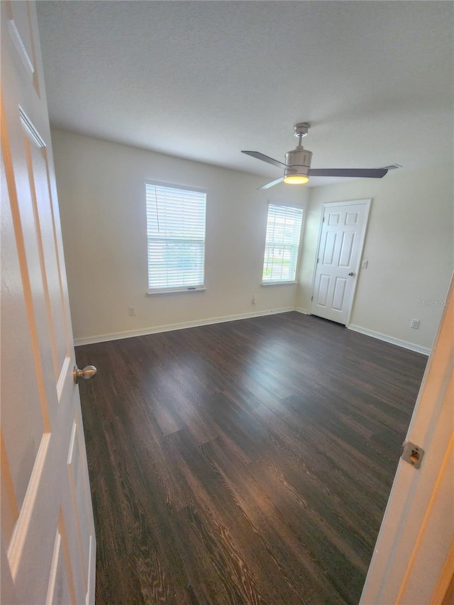 unfurnished bedroom with ceiling fan and dark hardwood / wood-style floors