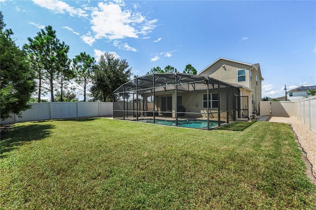 back of house featuring a lawn, a lanai, and a fenced in pool