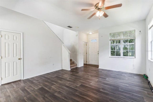 unfurnished living room with visible vents, baseboards, dark wood-style floors, ceiling fan, and stairs