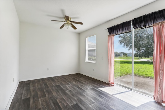 unfurnished room with baseboards, dark wood finished floors, and a ceiling fan