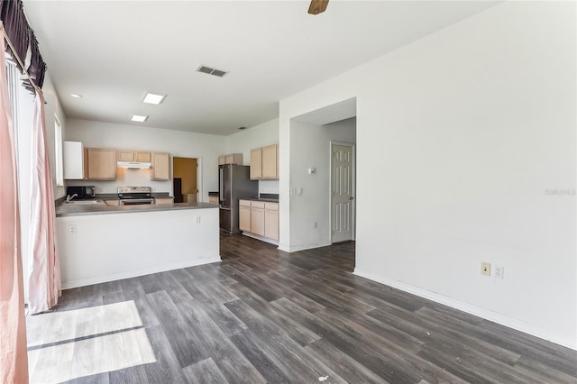 kitchen featuring light brown cabinets, under cabinet range hood, appliances with stainless steel finishes, dark wood-style floors, and dark countertops