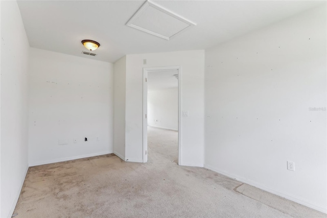 unfurnished room featuring attic access, visible vents, light carpet, and baseboards