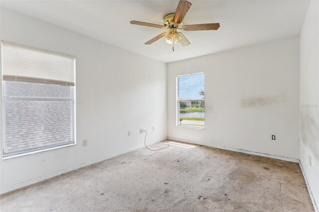 carpeted spare room featuring ceiling fan