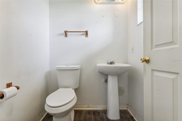 bathroom featuring baseboards, toilet, and wood finished floors