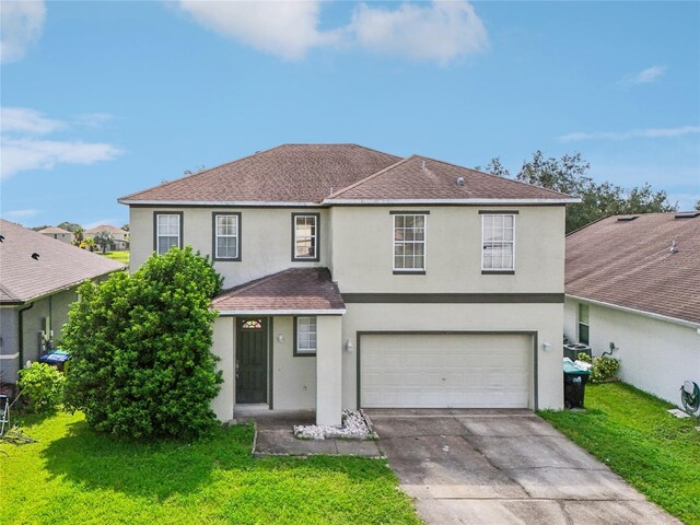 view of front property featuring a garage and a front lawn