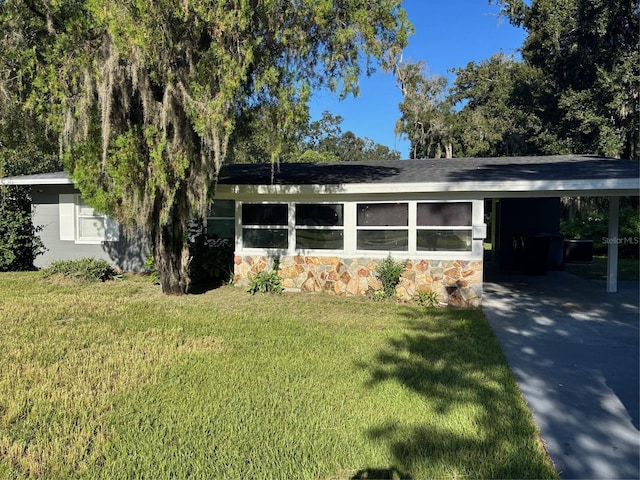 view of front of house featuring stone siding, a carport, and a front yard