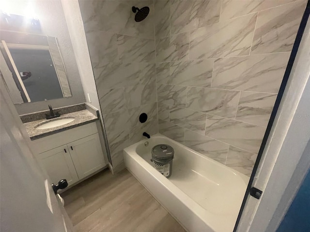 bathroom featuring vanity, wood finished floors, and bathing tub / shower combination