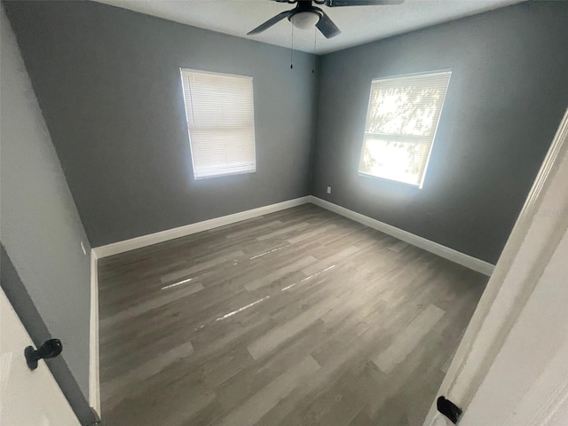 spare room with ceiling fan, baseboards, and wood finished floors