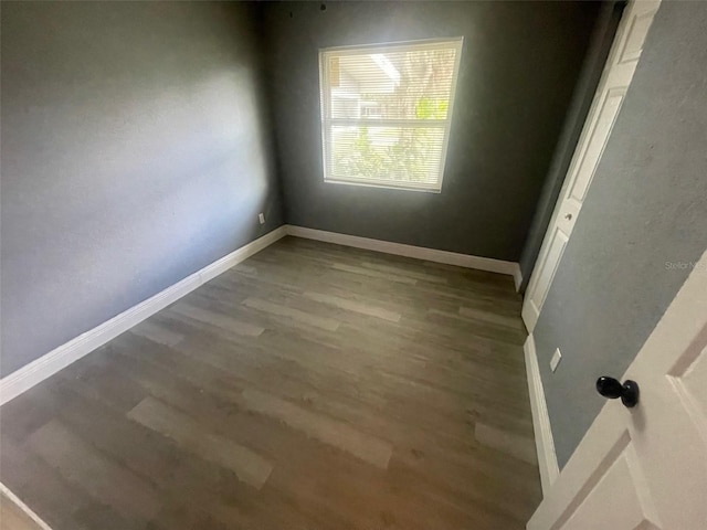 spare room with wood finished floors and baseboards