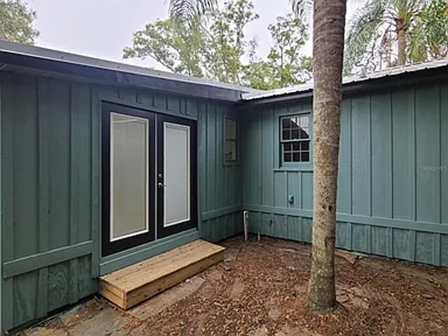 doorway to property featuring board and batten siding and metal roof