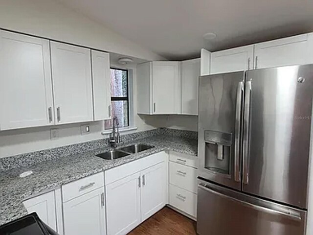 kitchen with sink, white cabinets, dark wood-type flooring, and stainless steel refrigerator with ice dispenser