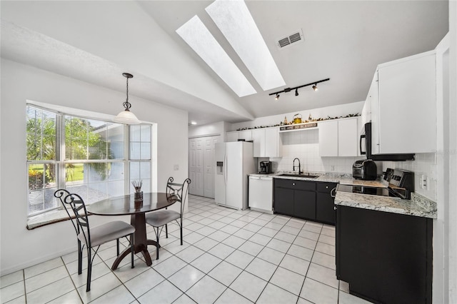 kitchen with white cabinetry, lofted ceiling with skylight, light tile patterned floors, and white appliances