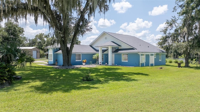 back of property with a yard and an outdoor structure