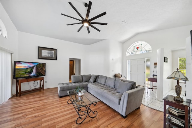 living room with ceiling fan, light hardwood / wood-style flooring, and lofted ceiling