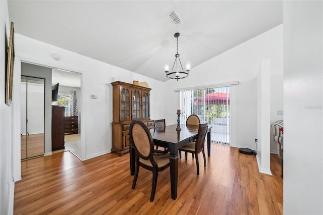 dining room with a wealth of natural light, vaulted ceiling, and wood-type flooring