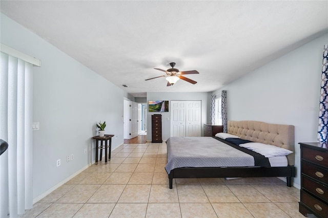 tiled bedroom with ceiling fan and a closet