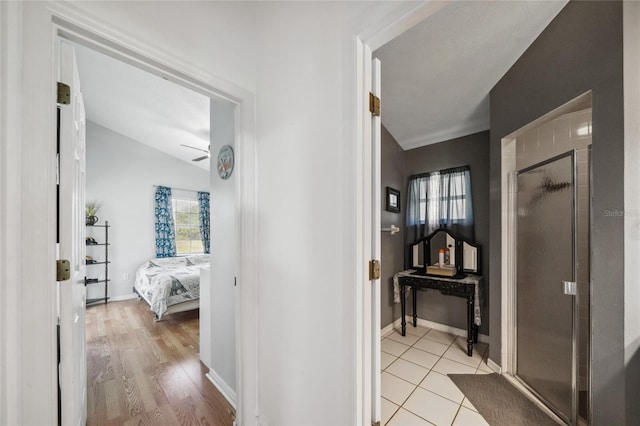 hall with light hardwood / wood-style flooring and lofted ceiling