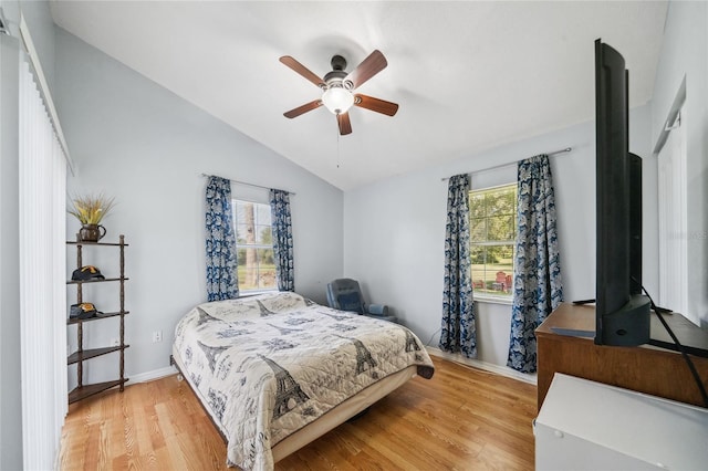 bedroom with ceiling fan, vaulted ceiling, and light hardwood / wood-style flooring