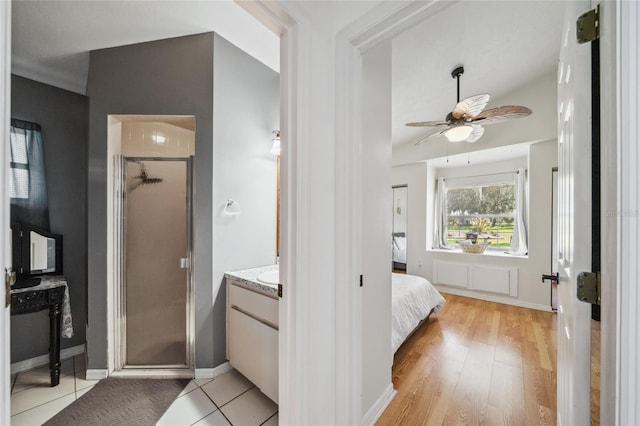 bathroom featuring a shower with shower door, ceiling fan, hardwood / wood-style floors, and vanity