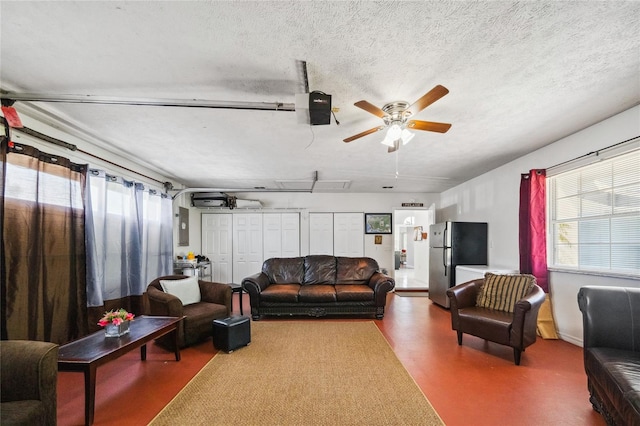 living room featuring a textured ceiling and ceiling fan