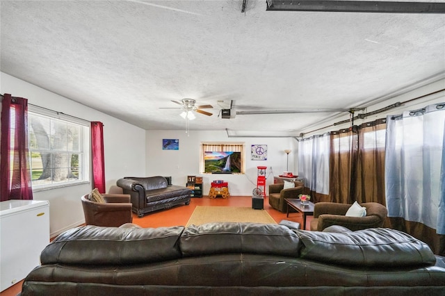 living room with ceiling fan and a textured ceiling