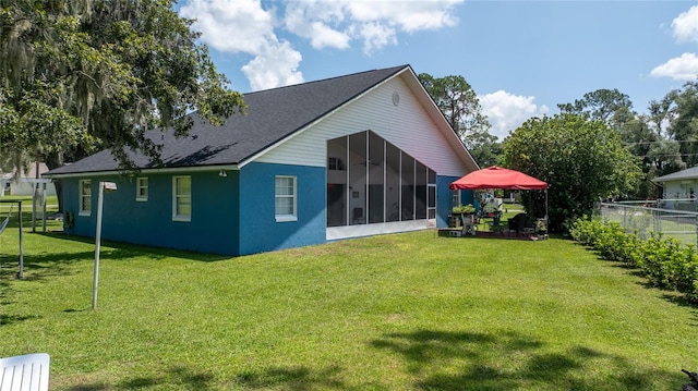 back of house with a sunroom and a yard