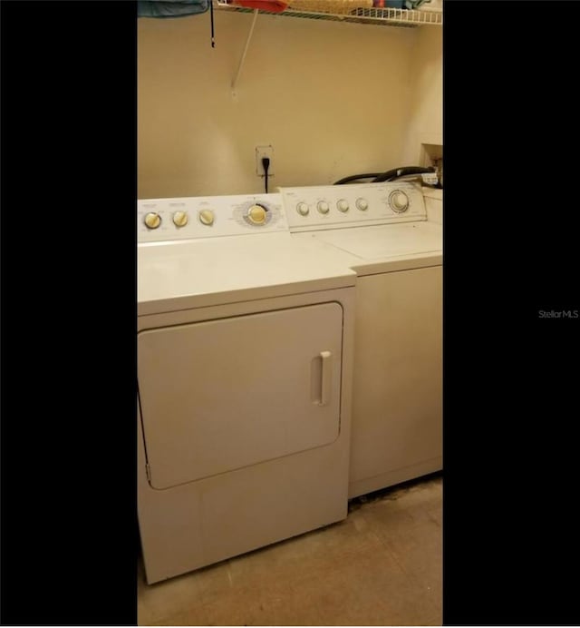 laundry room with light tile patterned floors and washing machine and clothes dryer