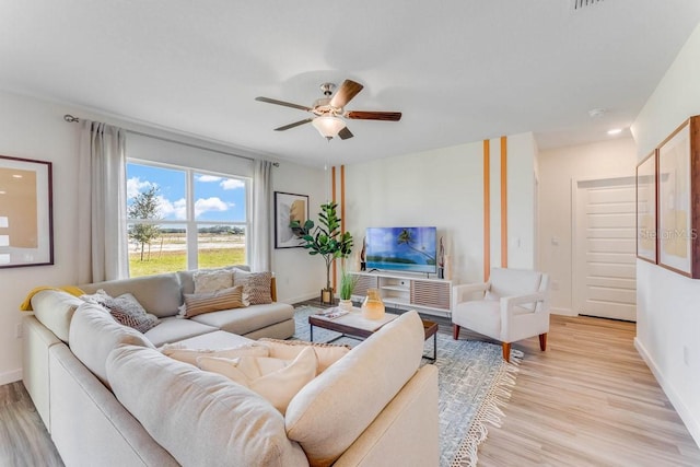 living room with light wood-type flooring and ceiling fan