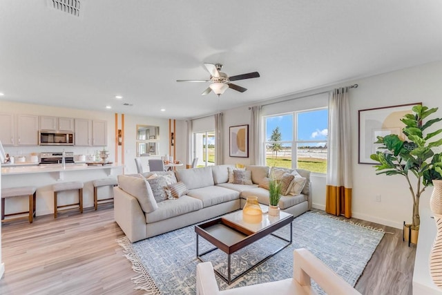 living room with ceiling fan, a healthy amount of sunlight, and light hardwood / wood-style floors