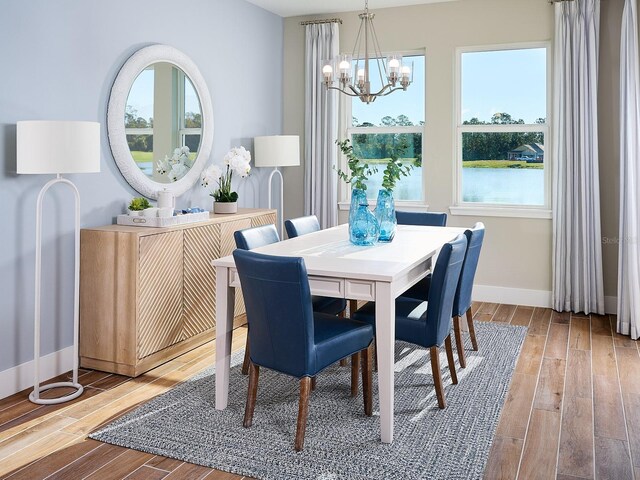 dining space with light hardwood / wood-style flooring and a notable chandelier