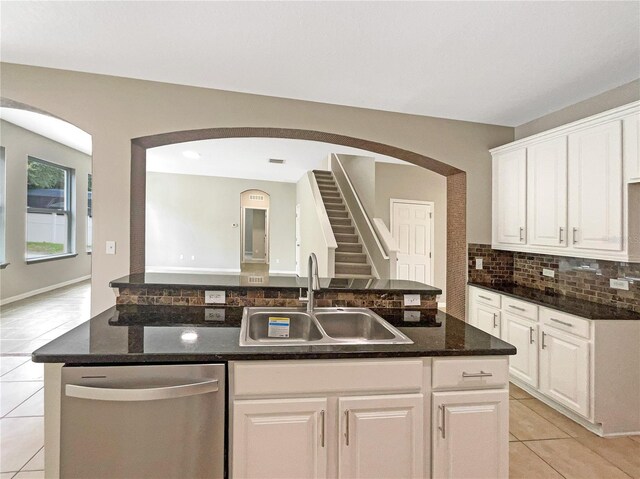 kitchen featuring light tile patterned flooring, a kitchen island with sink, a sink, white cabinetry, and dishwasher