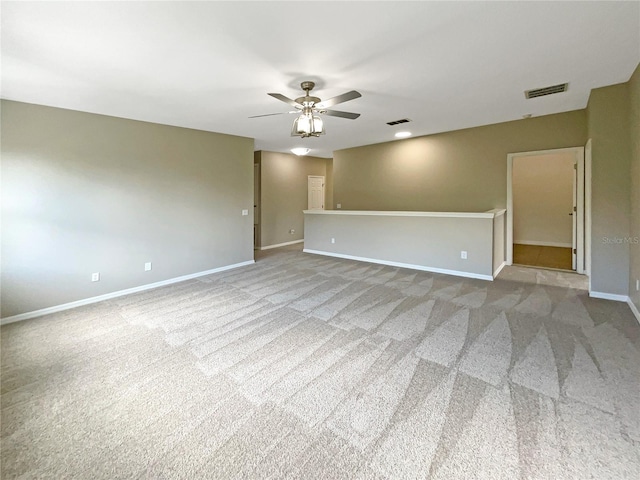 spare room with ceiling fan, visible vents, and baseboards