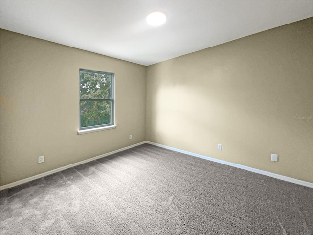 empty room featuring carpet floors and baseboards