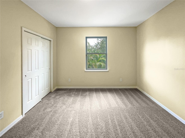 unfurnished bedroom with carpet floors, a closet, and baseboards