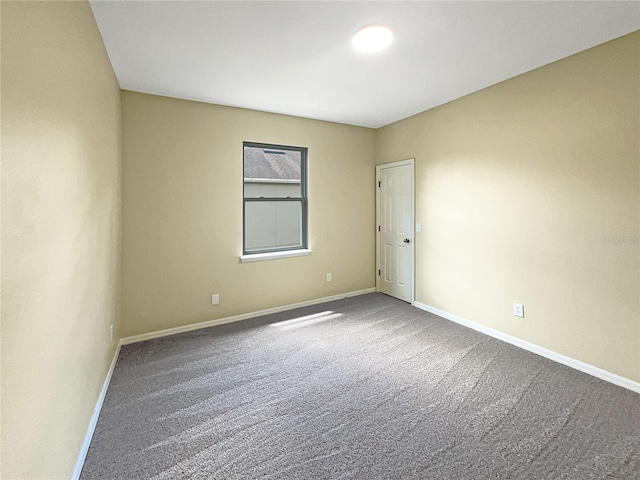 carpeted empty room with baseboards