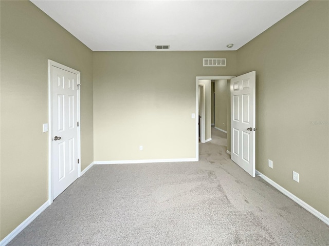 unfurnished bedroom with visible vents, light carpet, and baseboards