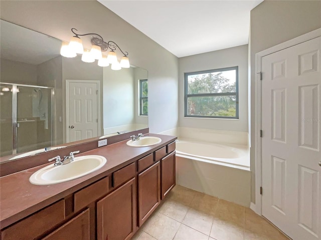 bathroom with a garden tub, a stall shower, a sink, and tile patterned floors